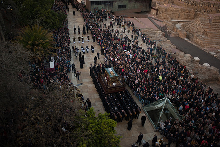 A general view of the procession with penitents of "Sepulcro" brotherhood and people watching the procession during the Holy Week in Malaga. The Holy Week in Andalusia is a on the most important and famous religious feast from Spain. Every year, thousands of christian believers celebrate the Holy Week of Easter with the crucifixion and resurrection of Jesus Christ.