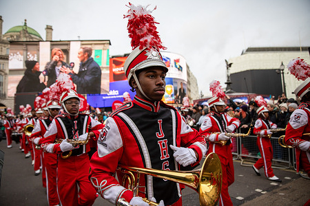 Members of a US high school marching band perform during the New Year's Day Parade. The London New Year's Day Parade, held annually on January 1st since 1987, showcases more than 8,000 participants, including international bands, cheerleaders, large inflatables, and floats, progressing from Piccadilly to Westminster. The parade attracts up to one million spectators who watch the event free of charge along a route passing notable landmarks such as Piccadilly Circus and Trafalgar Square, providing a celebration of global music and culture.