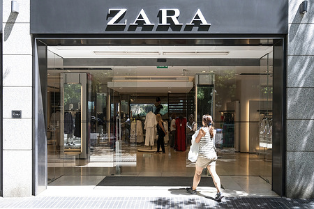 A shopper enters the Spanish multinational clothing design retail company by Inditex, Zara, a store in Spain.