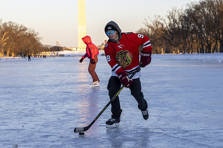 A man play hockey on the frozen Lincoln Memorial Reflecting Pool during an extended period of extreme cold weather affecting much of the eastern United States.