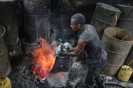 A worker seen clearing hot embers after the production of Illicit brew in Kibera Slums.
The low wages and lack of job opportunities in Kenyan slums has forced many residents to turn to high consumption of the most toxic traditional brew well known as changaa . It is mostly prepared using some of the most dangerous chemicals like methanol to increase the strength of alcohol content in it. Due to government struggles and failure to stop the high consumption, the drink was later legalized in September 2010 by the Kenyan Government. It has since become one of the most practiced business for most poverty stricken families so as to make ends meet.