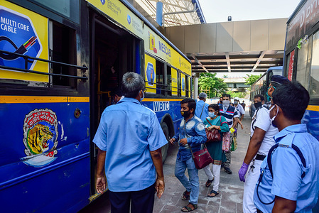 Traffic officers count passengers entering in a bus at a bus station amid coronavirus crisis.The West Bengal state government has decided to allow operators of buses to carry only 20 passengers at a time with strict health and safety measures as government opens transportation.