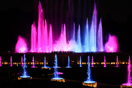 View of the illuminated Fountain Show at Longwood Gardens during an evening performance in Kennett Square. The choreographed display combines water fountains, colorful lighting, and music, attracting visitors to one of the United States' premier botanical gardens.