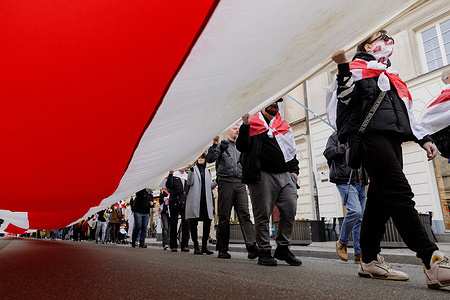 Participants carry a 330-meter-long historic white-red-white Belarusian flag during a Freedom Day (Dzien Voli) rally in central Warsaw. Freedom Day (Dzien Voli) is one of the most important dates observed by the Belarusian opposition. It marks the March 25, 1918 declaration of independence of the Belarusian Democratic Republic. Belarusian authorities reported to intimidate members of the diaspora worldwide, warning they may be identified and that their relatives or property in Belarus could face repercussions. As a result, some participants choose to conceal their faces.