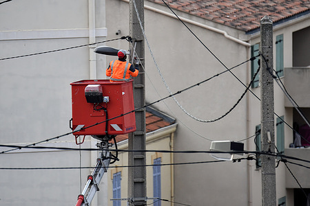 An electrician on a mobile elevating work platform is installing a new streetlights in L'Estaque in the northern districts of Marseille.