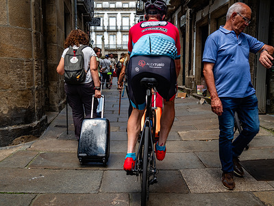 Pilgrims walk and ride bikes as they pass by a local resident. Unstoppable rise in pilgrim numbers: The Way of St James continues to gain traction and could break its pilgrimage record for the fourth time in a row by the end of 2025.
More than 2,000 pilgrims a day are currently arriving in Santiago on the most relevant routes, the French and Portuguese Way. However, the mass movement also brings with it bottlenecks in accommodation and complaints from residents in the historic centre of Santiago about increasing noise pollution.