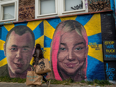 (EDITORS NOTE: Image contains profanity)
A woman walks by murals on the wall of two young Ukrainian victims. On the left, Vitaliy Skakun Volodymyrovych (1996-2022) who is seen as a hero by the Ukrainian army for his heroic action during the explosion of a bridge to stop the Russian army, on the right, 10 year old Ukrainian Polina, murdered by Russian soldiers when she and her family tried to flee Kyiv by car. The wall of the Street Museum at the NDSM wharf has been decorated with portraits of two victims of the war in Ukraine. Street artist Magdalena Anopsy painted them as a tribute.