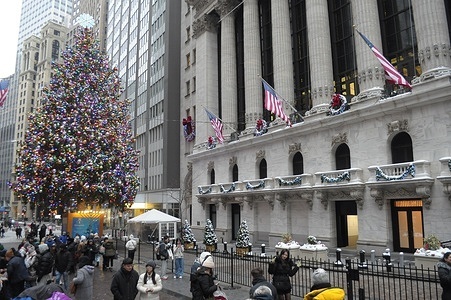 People walk past the New York Stock Exchange, which is seen next to a Christmas tree in the Financial District in Manhattan, New York City.