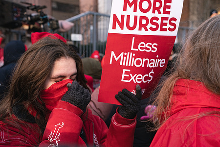 A nurse holds a sign that reads "Morse nurses, less millionaire exec$" during a picket outside of Mount Sinai West on Tuesday, 20 January 2026 in New York, New York, USA.