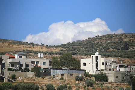 A summer cloud seen over the mountains and olive groves with Palestinian homes pictured, east of the city of Nablus in the northern West Bank.