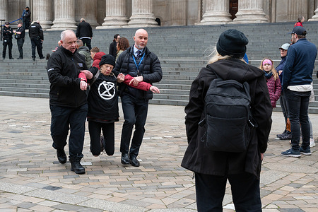 A protester is carried away by security during the Good Friday demonstration at the steps of St Paul’s Cathedral. Members of Christian Climate Action staged a Good Friday protest outside St Paul’s Cathedral, calling for action against environmental destruction under the slogan “Don’t crucify creation.” Four protesters—James Grote, 69, a Baptist minister; Sue Parfit, 84, a Church of England priest; Sue Hampton, 69, a writer; and Deborah Wilde, 71, a retired teacher—chained themselves to a wooden cross before being carried away by cathedral security as the demonstration concluded.