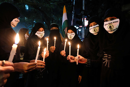 Muslim women hold lit candles during a demonstration at a government-run high schools in India's Karnataka state where Muslim students were told not to wear hijabs at the institute premises.