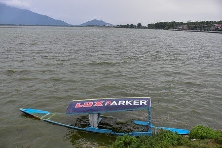 A submerged boat is seen in Dal lake during a stormy weather in Srinagar. At least two people drowned after a boat capsized in Dal Lake amid gusty winds. However, one among them has been rescued while the search operation is going on to trace the other missing individual.