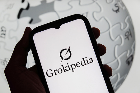 In this photo illustration, a Grokipedia logo is displayed on a smartphone and a Wikipedia logo in the background.