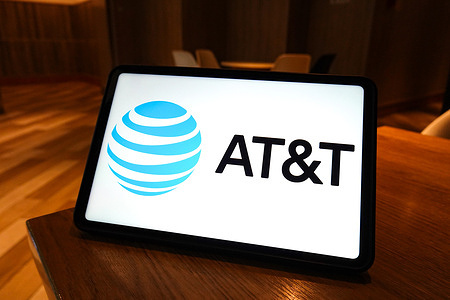 In this photo illustration, the logo of AT&T is displayed on the screen of a smart tablet.