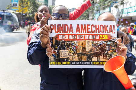 Small-scale traders seen holding a placard during a protest over a new Kenya Revenue Authority (KRA) customs valuation benchmark along Moi Avenue central business district. Small-scale traders closed shops and protested a new KRA customs valuation benchmark in Nairobi, marching towards Times Tower as police used tear gas to disperse crowds. The demonstrations disrupted businesses and traffic in parts of the central business district.
