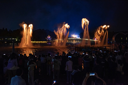 On the Mid - Autumn Night, performers are putting on a flame show, soaring above the water with water jets while flames shoot up. The Mid - Autumn Festival is a significant traditional Chinese festival, symbolizing family reunion and full of poetic and cultural connotations. On Mid - Autumn Night, as people gather to admire the full moon and share the joy of reunion, flame performances have become a captivating part of the festive celebrations.