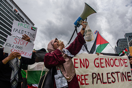 Protesters chanting slogan hold placards expressing their opinions during the demonstration on the Rama I road. Pro-Palestinian protesters marched on the Rama I road in Bangkok, Thailand to show their solidarity with Palestinians and mark one year of the Israeli operations in the Gaza Strip and to call for a permanent ceasefire.
