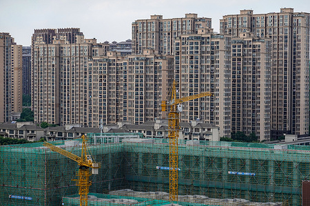Two yellow hanging towers work at a construction site, with towering residential buildings in the background. The World Bank said in a report released on June 8th that it has revised its economic forecast for China down to 4.3 percent this year, from 5.1 percent in December, amid deterioration in the global environment and the spread of covi-19. The report added that China's growth momentum is expected to rebound in the second half of 2022, boosted by aggressive fiscal stimulus, monetary easing and a further relaxation of housing sector regulation. The country's gross domestic product growth is expected to rise to 5.2 percent in 2023.