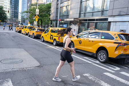 New York City yellow cab taxi parked curbside awaiting passengers near a crosswalk at Columbus Circle on June 09, 2028 in New York City.