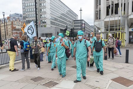 Doctors protest during Extinction Rebellion's Impossible Rebellion protest continues march to the Department for Business Energy and Industrial Strategy under the banner of Stop The Harm protesting against climate change, global warming, and plans to target the root cause of the climate and ecological crisis and to demand the government divest from fossil fuel companies.