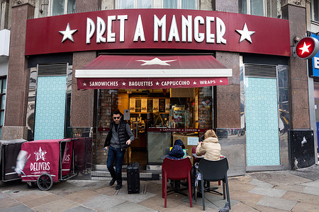 People are seen in front of a Pret A Manger store in Leicester Square.