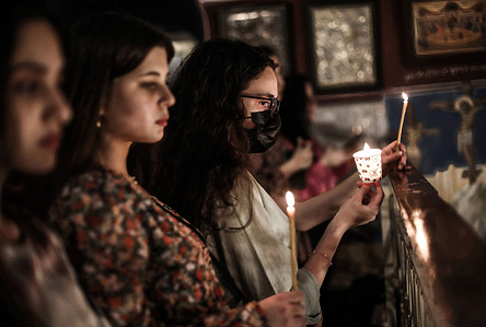 Christians hold candles as they attend an Orthodox service during Easter night at the Church of Saint Porphyrius.