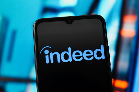 In this photo illustration, the Indeed logo is seen displayed on a smartphone screen.