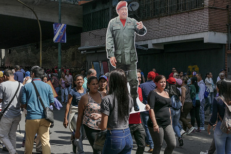 A woman seen with a portrait of Hugo Chavez in downtown Caracas.
Venezuelan President Nicolas Maduro started a second term, defying critics in the United States and Latin America who called him an illegitimate usurper of a nation where economic chaos has wrought a humanitarian crisis. The National Assembly calls the Maduro government a "dictatorship and usurpation of power." Currently Venezuela is experiencing its worst economic crisis with an inflation rate of over 1,000,000%.