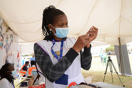 A healthcare worker prepares to administer the Pfizer vaccine to a resident of Dagoretti in Nairobi during a mass vaccination drive countrywide.