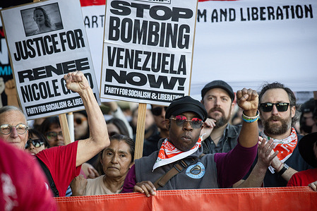 Protesters march holding signs reading “Justice for Renee Nicole Good” and “Stop Bombing Venezuela Now,” raising clenched fists during an ICE Out of Los Angeles demonstration organized by the Party for Socialism and Liberation.