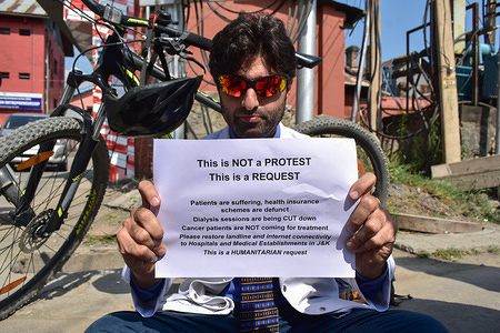A doctor holds a placard as he protests against the communication blocade in Srinagar, Kashmir. 
A lone doctor was protesting against the anti-cancer drug shortage due to the Communication blockade imposed by the authorities post abrogation of Article-370 which gives special status to Jammu and Kashmir.