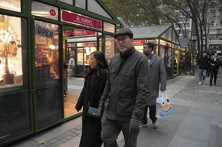 People walk in Bryant Park Winter Village, a seasonal holiday-themed venue full of vendors and an ice skating rink, in Manhattan, New York City.