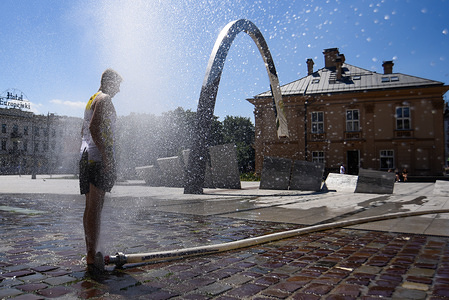 A man cools off in the spray from a fire water hose next to a Krakowska shopping mall during the high temperatures in Krakow.
A June record was also set in Poland when temperatures soared to 38.2 C (100.8 F) in Radzyn on Wednesday.