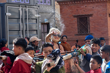 A boy splashes water while taking part in a traditional procession during the Madhav Narayan festival in Thecho. Devotees across the Kathmandu Valley observe the month-long festival, also known as Swasthani Purnima, dedicated to Lord Shiva.