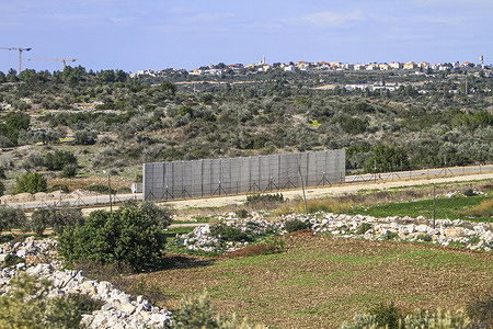Israeli bulldozer seen building a new section of the separation wall Between the village of Aqaba near Jenin in the West Bank and the road between the Israeli settlement of Harmash and the towns of Ara and Baqa al-Gharbiya inside the Israeli separation wall.