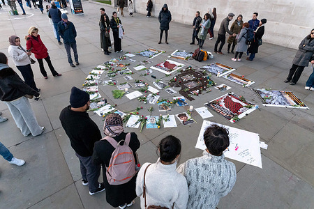 Protesters gather around a display of photos of killed protesters during the demonstration. Iranian protesters gathered in Trafalgar Square in London to hold a candle-lit vigil commemorating those killed during the recent nationwide uprisings against the Islamic Republic of Iran’s violent crackdown. Demonstrators mourned the victims of state repression — with credible reports suggesting thousands have died amid the unrest — and emphasised solidarity with protesters inside Iran, lighting candles and holding a moment of silence to honour lives lost under the regime’s use of lethal force.