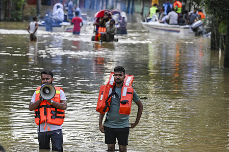 Volunteers help local to wade through floodwater in Feni district in Chittagong division. Flood affected area in Feni district in Chittagong division, Bangladesh. The floods were caused by heavy monsoon rains and have resulted in multiple deaths.