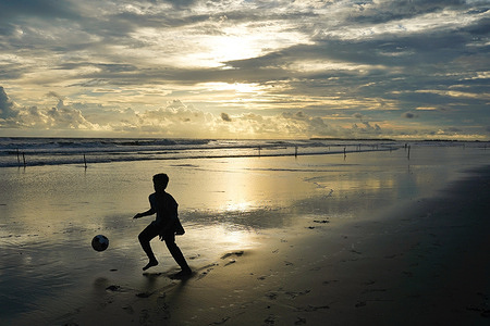 A silhouette of a local child seen playing with a football at the world longest beach in Cox's Bazar.
This is the part of the coastline of the Bay of Bengal which is claimed to be the longest natural sea sandy beach in the world, running 120 kilometers.