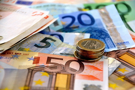 In this photo illustration the Euro banknotes and coins are seen displayed.