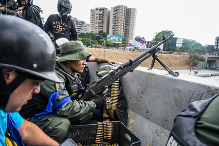 An anti government solider seen with his machine gun taken up position ready for battle.
Venezuelan military who are supporting the Venezuelan opposition leader Juan Guaido took to the street with their weapons together with anti government protesters in a military coup against the socialist government lead by President Nicolas Maduro.