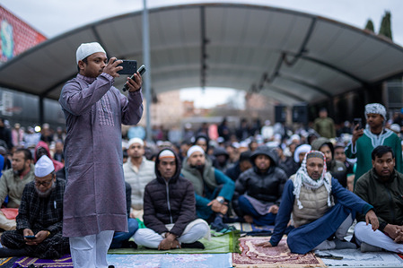 A man records with his mobile phone during the celebration of Eid al-Fitr, the prayer that marks the end of Ramadan, at the Lavapiés neighborhood of Madrid.