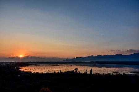 The sun sets behind the mountains at the second largest fresh-water lake of Asia, Wular Lake situated on the foothills of Haramuk Mountain about 75kms from Srinagar, the summer capital of Jammu and Kashmir.