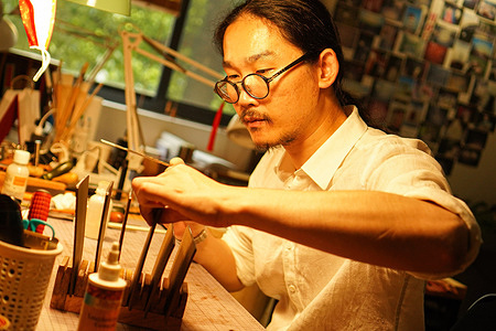 Yi Sih Zen is working at his table in his studio in Suzhou. Yi Sih Zen is the founder of the brand CATENATVS (literally "the chained man") in Suzhou. CATENATVS produces high-quality leather products with skins imported from France and Italy. It is one of the few workshops to produce hand-made leather goods in Suzhou.