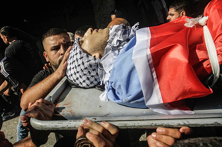 (EDITOR'S NOTE: Image depicts death) Mourners carry the body of Ayed Abu Harb, 21, a member of the Islamic Jihad militant group, during his funeral in the Nour Shams refugee camp in the northern West Bank. Palestinian health officials say Israeli troops killed Abu Harb during an army raid in the occupied West Bank. The Israeli military said Palestinian gunmen came under fire during an operation to destroy an explosives stockpile in the refugee camp.