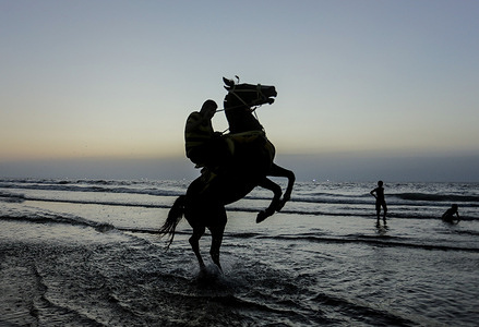 A Palestinian man rides his horse on a beach during the sunset in Gaza City. The sea is the only place for the people of the Gaza Strip to entertain themselves or spend their spare time. With high unemployment and lack of job opportunities in Gaza, an increasing number of families are facing poverty after losing their jobs due to the blockade imposed on Gaza for 13 years. Some of them go to work in fishing, selling corn or renting horses.