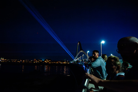 People seen looking at the light towers illuminating the sky. This year, 80 years after Operation Market Garden, during the Sunset March, which has been held since 2014, as a tribute to the allied soldiers who fought for the freedom of the Netherlands. The march had thousands of people crossing the Oversteek bridge to honor WWII heroes.