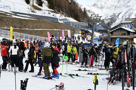 Skis and skiers on snow slopes at Mont Blanc massif in Alps Courmayeur.