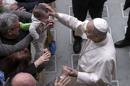Pope Leo XIV greets a child during a meeting with collaborators and volunteers of the 2025 Jubilee in the Paul VI Hall at the Vatican.