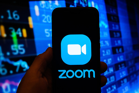 In this photo illustration a multiple exposure image shows a Zoom video logo displayed on a smartphone with stock market percentages in the background.